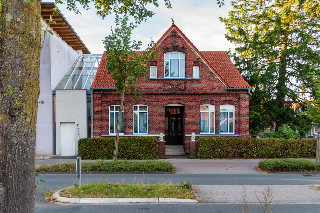 Red brick house with a clay tile roof, restored timber door and new windows
