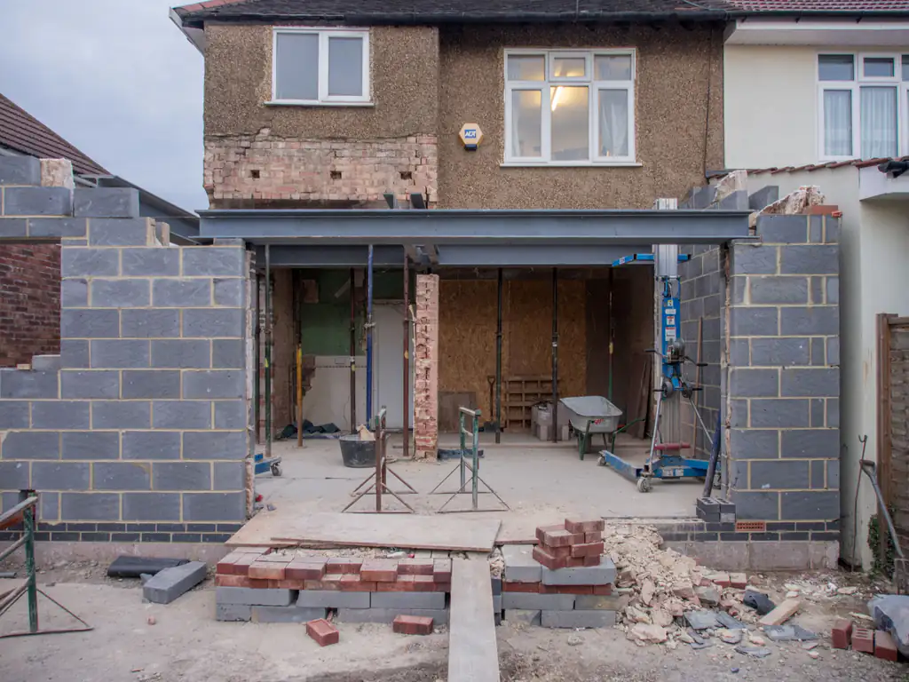 Rear extension under construction, with new blockwork walls and a steel beam on props